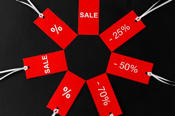 Red tags with discount signs on black background — Stock Photo, Image