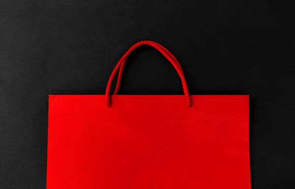 Bolso de compras rojo sobre fondo negro — Foto de Stock