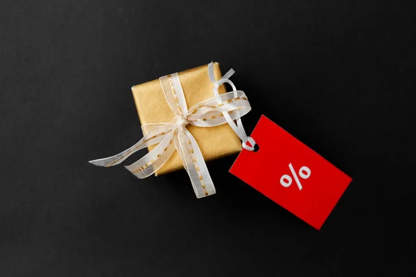 Pequena caixa de presente e etiqueta de venda vermelha com sinal de desconto — Fotografia de Stock