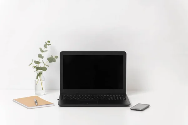 Ноутбук с черным экраном на белом столе офиса — стоковое фото