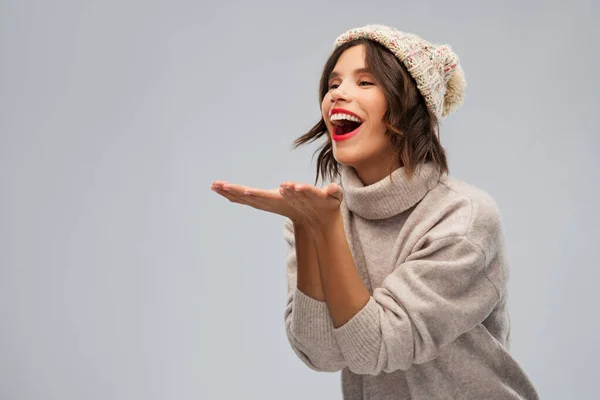 Jovem mulher de malha chapéu de inverno enviando beijo de ar — Fotografia de Stock