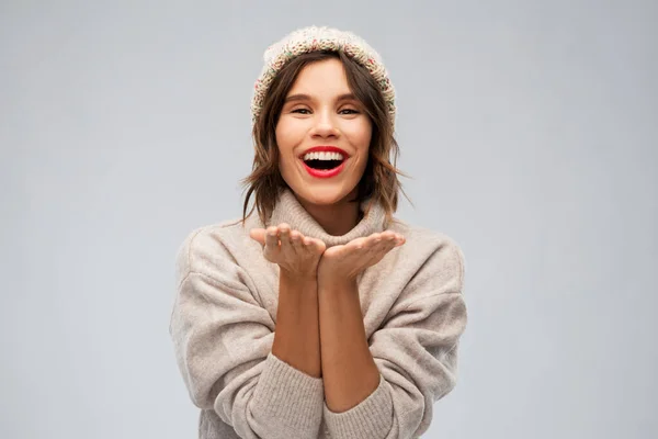 Junge Frau mit gestrickter Wintermütze schickt Luftkuss — Stockfoto