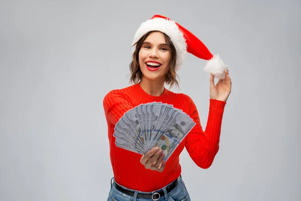 Mujer feliz en sombrero de santa con dinero en Navidad —  Fotos de Stock