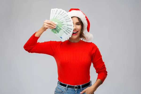 Szczęśliwa kobieta w kapeluszu Mikołaja z pieniędzmi na święta — Zdjęcie stockowe