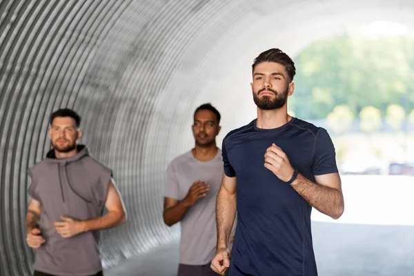 Young men or male friends running outdoors — Stock Photo, Image