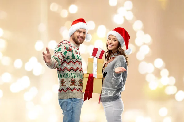 Casal feliz em camisolas de Natal com presentes — Fotografia de Stock