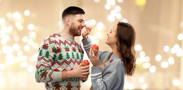 Couple avec des cupcakes en pulls de Noël laid — Photo