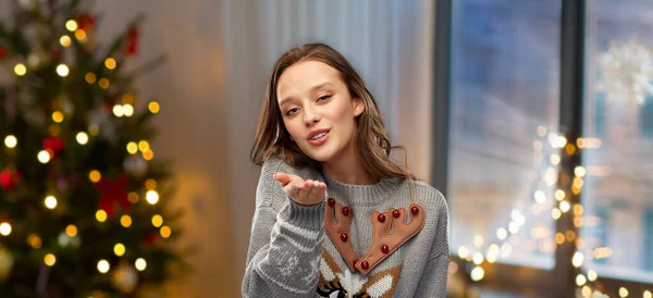 Woman in ugly christmas sweater sending air kiss — Stock Photo, Image