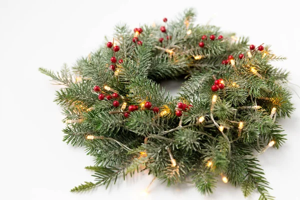 Grinalda de abeto de natal com bagas e luzes — Fotografia de Stock