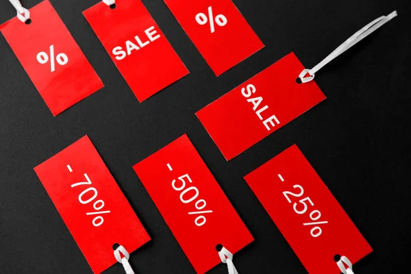 Rode tags met kortingsborden op zwarte achtergrond — Stockfoto