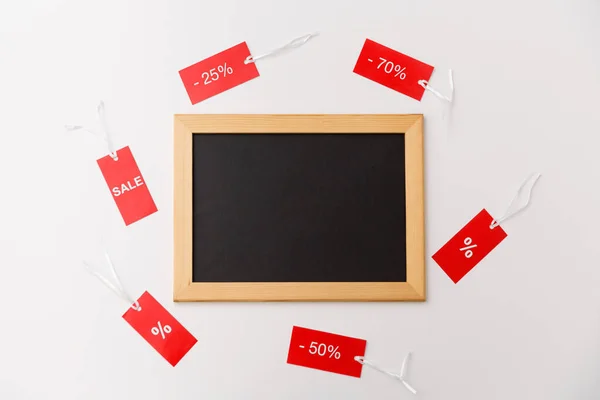 Chalk board and red tags with discount signs — Stock Photo, Image