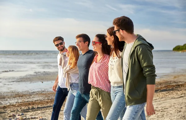 Amigos felizes andando ao longo da praia de verão — Fotografia de Stock