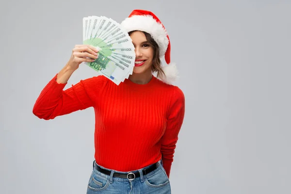 Boldog nő télapó kalap pénzzel karácsonykor — Stock Fotó