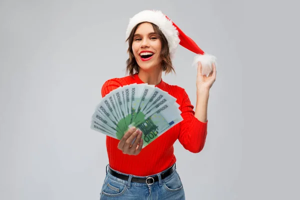 Mulher feliz em santa chapéu com dinheiro no Natal Imagem De Stock