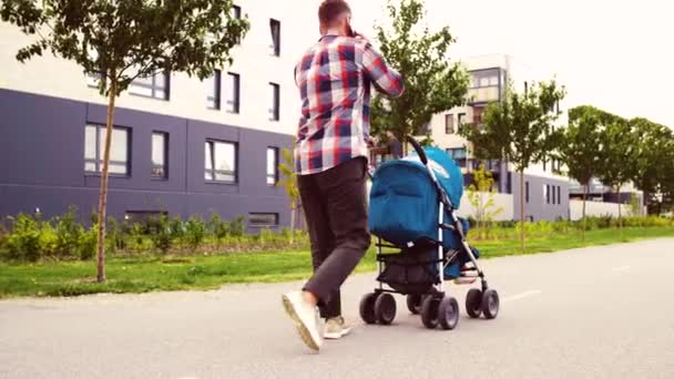 父亲与婴儿车调用智能手机在城市 — 图库视频影像
