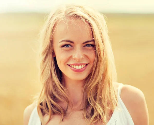 Giovane donna sorridente in bianco sul campo di cereali — Foto Stock
