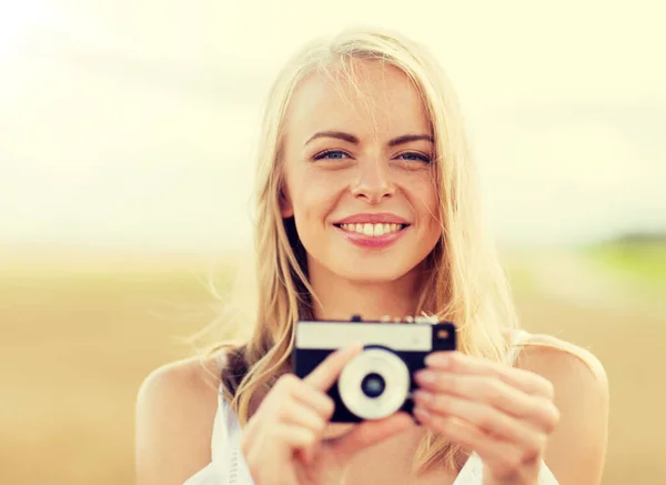 Gelukkig jonge vrouw met filmcamera buitenshuis — Stockfoto