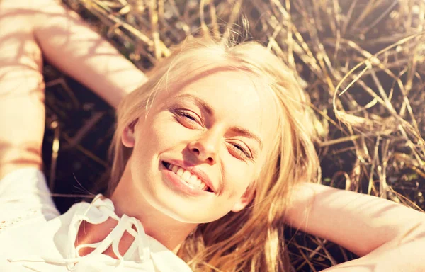 Щаслива молода жінка лежить на зерновому полі — стокове фото
