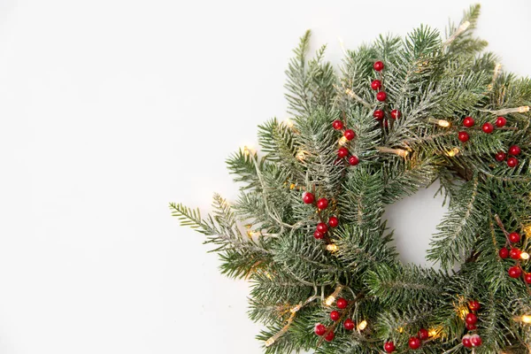 Corona de abeto de Navidad con bayas y luces — Foto de Stock