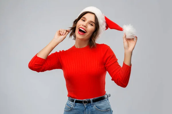 Ευτυχισμένη νεαρή γυναίκα με καπέλο Σάντα τα Χριστούγεννα. — Φωτογραφία Αρχείου
