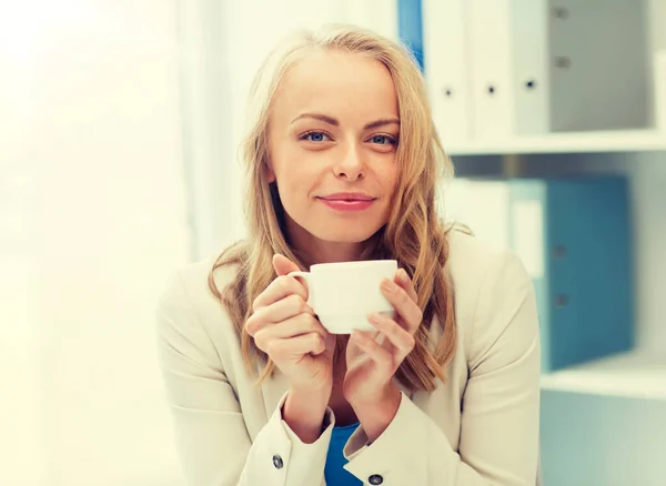 Zufriedene Geschäftsfrau trinkt Kaffee im Büro — Stockfoto