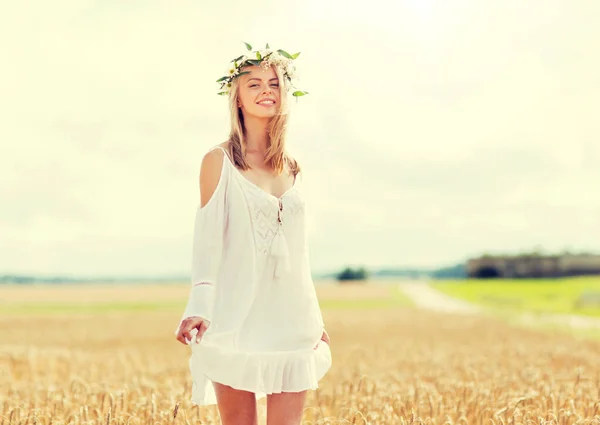 Gelukkig jong vrouw in bloem krans op graan veld — Stockfoto