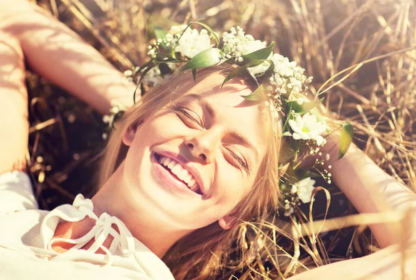 Mujer feliz en corona de flores acostada sobre paja —  Fotos de Stock