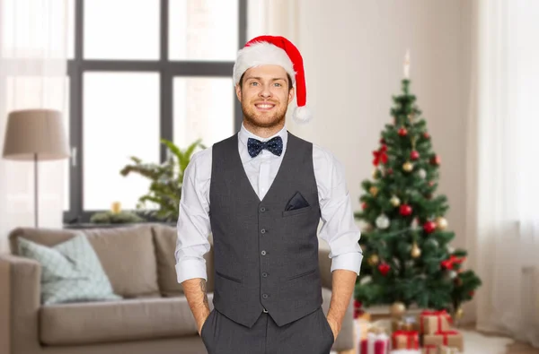 Man in santa hat and suit at home on christmas — Stockfoto