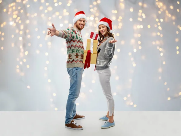 Szczęśliwa para w swetrach świątecznych z prezentami — Zdjęcie stockowe