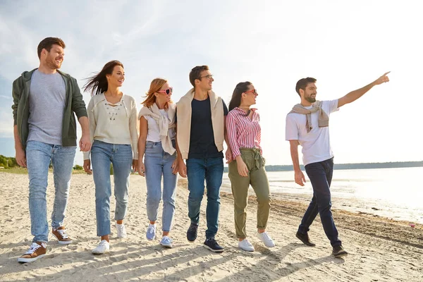 Amigos felices caminando por la playa de verano — Foto de Stock