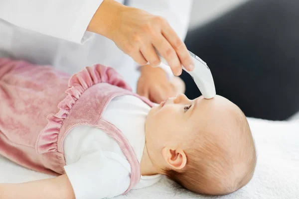 Arzt mit Thermometer misst Babytemperatur — Stockfoto