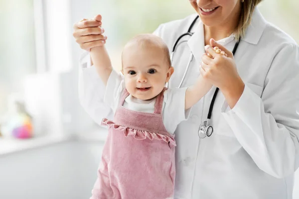 Vrouwelijke kinderarts arts met baby in kliniek — Stockfoto