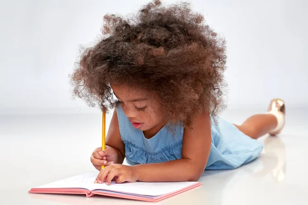 Feliz niña afroamericana con cuaderno de bocetos —  Fotos de Stock