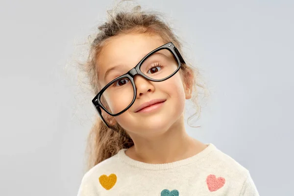 Niña sonriente en gafas colocadas torcidas — Foto de Stock