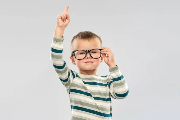 Porträtt av pojke i glasögon pekar finger upp — Stockfoto