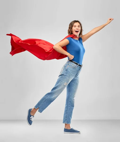 Щаслива жінка в червоному супергеройському мисі — стокове фото