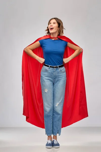 Gelukkig vrouw in rood superheld cape — Stockfoto