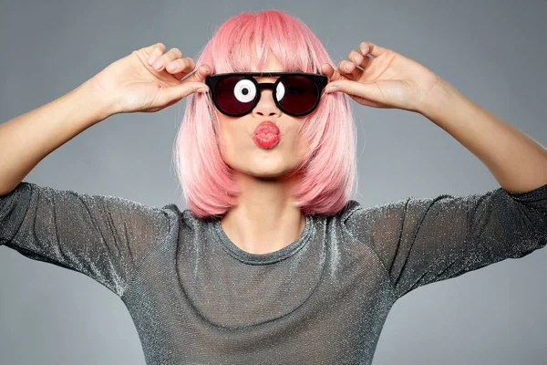 Mulher de peruca rosa e óculos de sol enviando beijo de ar — Fotografia de Stock