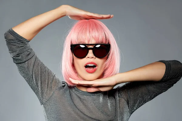 Szczęśliwa kobieta w różowej peruce i czarnych okularach — Zdjęcie stockowe