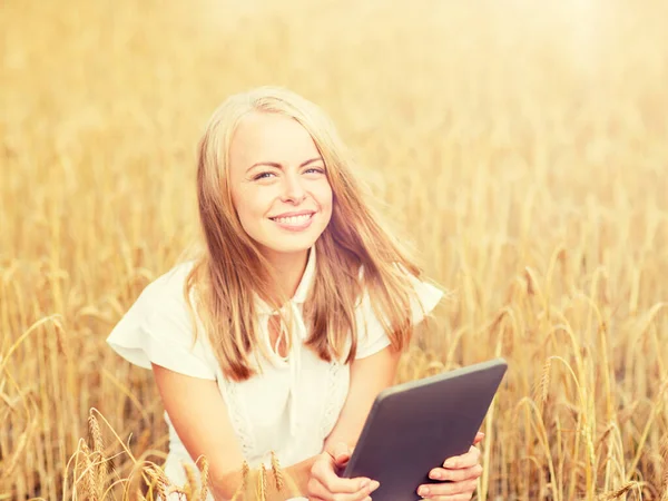 Jovem feliz com tablet pc no campo de cereais — Fotografia de Stock