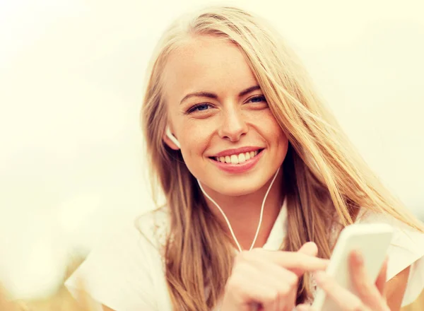 Mujer feliz con smartphone y auriculares —  Fotos de Stock