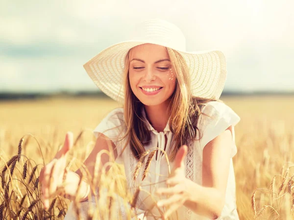 Heureuse jeune femme en chapeau de soleil sur le champ de céréales — Photo