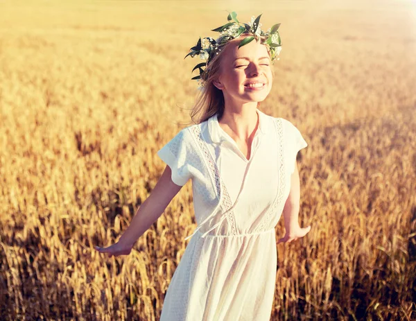 Feliz joven en corona de flores en el campo de cereales —  Fotos de Stock