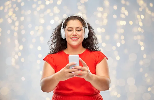 Vrouw in hoofdtelefoon luistert naar muziek op smartphone — Stockfoto