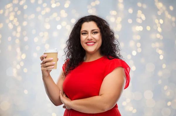 Mulher em vestido vermelho segurando taça de café takeaway — Fotografia de Stock