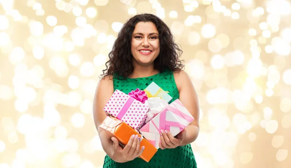 Mujer feliz sosteniendo cajas de regalo sobre luces —  Fotos de Stock