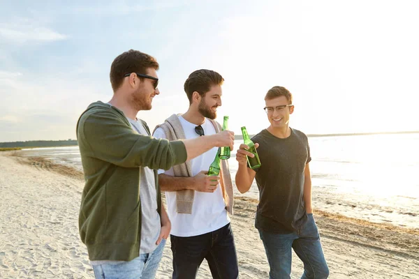 Homens jovens brindando cerveja não alcoólica na praia — Fotografia de Stock