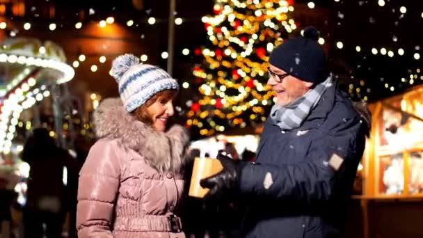 Szczęśliwa para starszy z prezent na Jarmark bożonarodzeniowy — Wideo stockowe