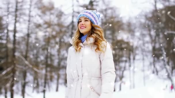 Счастливая улыбающаяся женщина, гуляющая по зимнему парку — стоковое видео