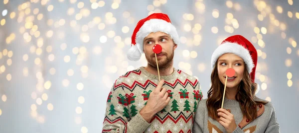 Pareja con accesorios de fiesta de Navidad en suéteres feos — Foto de Stock